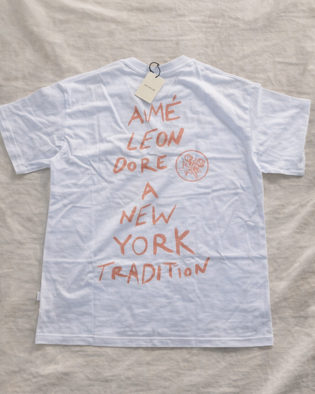 Aime Leon Dore White Back-Print T-Shirt with Peach Hand‑Lettered Graphic — vintage back-print tee hero ecommerce image